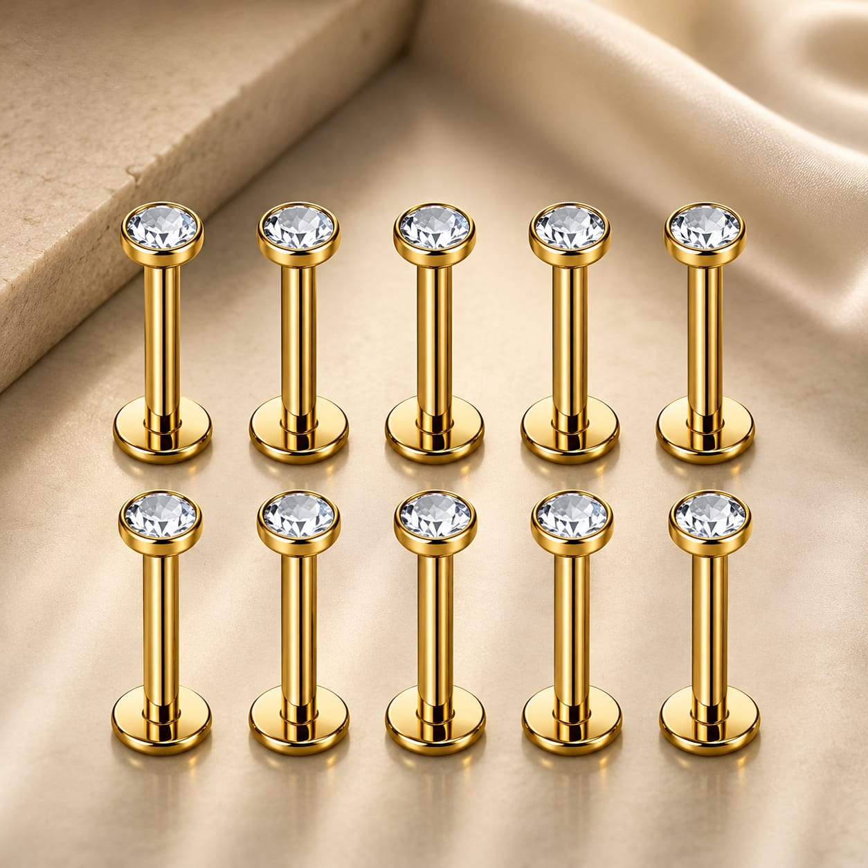 Assortiment de 10 piercings aux finitions variées : or jaune classique, argenté moderne, pierres noires au style rock et cristaux transparents scintillants.