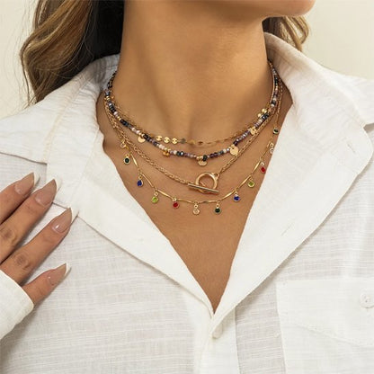 Bijou quatre rangs doré porté sur une chemise blanche