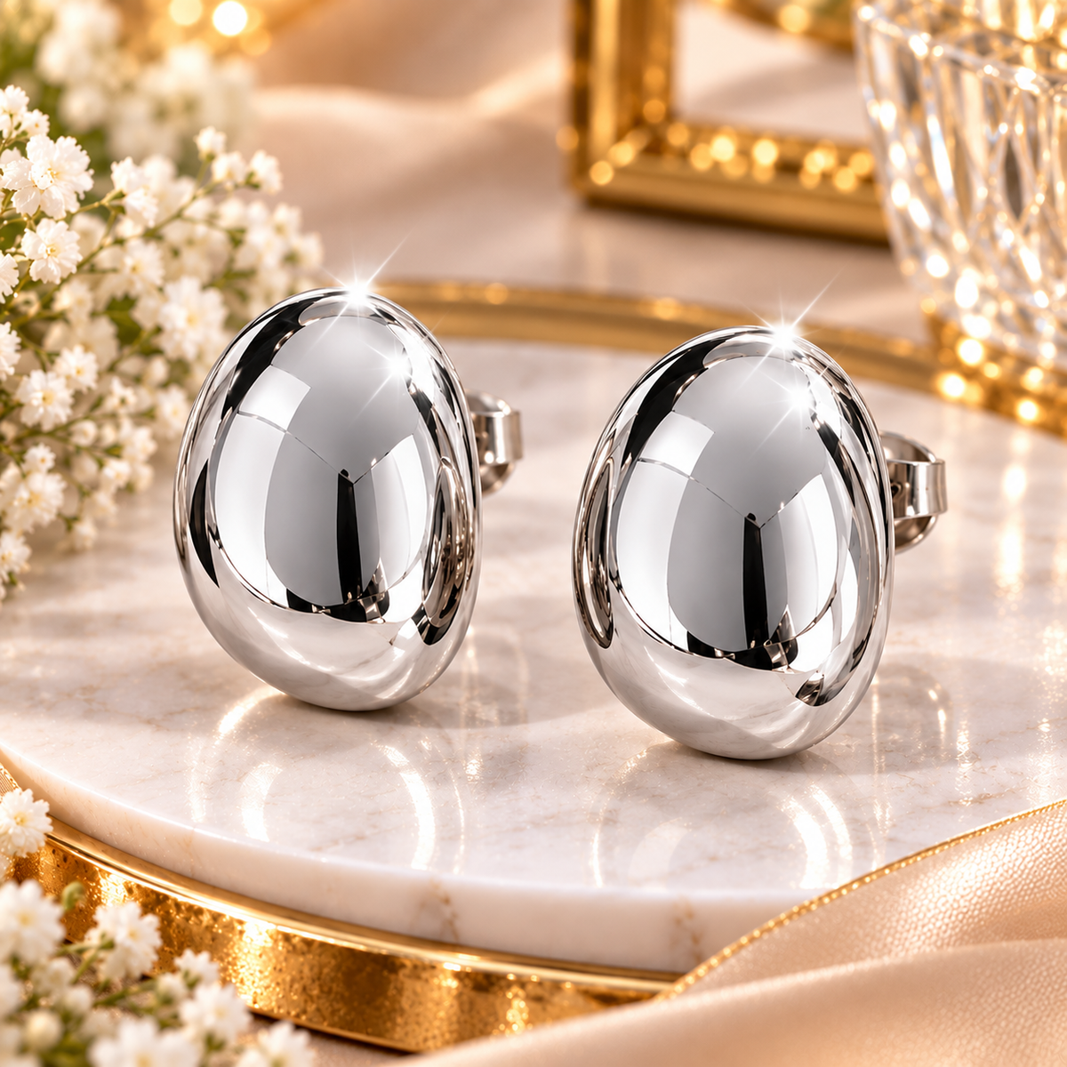 Boucles d'oreilles ovales bombées en métal poli pour femme.