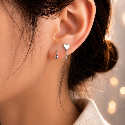 Conch piercing spiralé avec étoile et cœur en acier.


