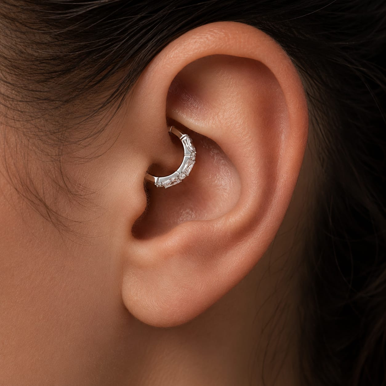 Modèle portant un piercing conche scintillant en titane médical