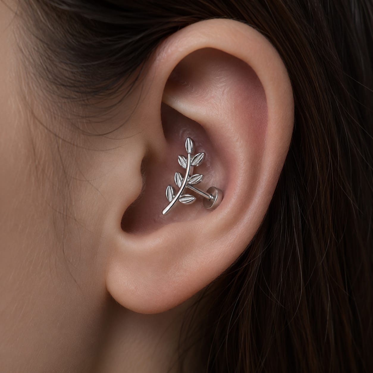 Un magnifique piercing conch habillant le creux auriculaire.