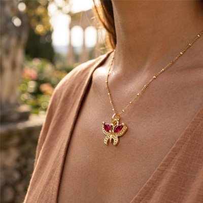 Zoom sur les détails dorés des pendentifs femme papillon.